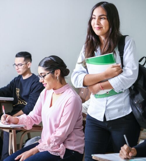 woman carrying white and green textbook