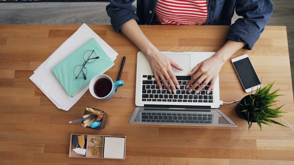 Photo by Vitaly Gariev a woman sitting at a table working on a laptop